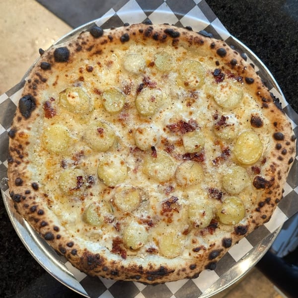 Pop-Start Pizza's white pizza with sliced potatoes, cheese, and a charred crust on a metal tray.